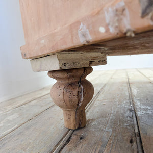 An antique Victorian pine chest of drawers from the 19th century featuring four drawers fitted with decorative brass handles. The chest is topped with a shaped gallery back and raised on turned tulip bun feet.