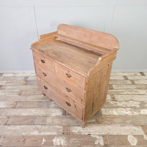 An antique Victorian pine storage chest from the 19th century with four drawers arranged in a two-over-two layout. The chest is fitted with decorative brass handles and raised on tulip bun feet beneath a shaped gallery back.