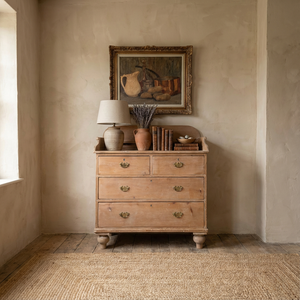 An antique Victorian pine chest of drawers from the 19th century with four drawers arranged in a two-over-two layout. The drawers are fitted with decorative brass handles, and the chest is raised on turned tulip bun feet with a shaped gallery back.