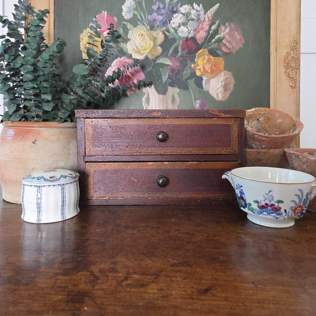 Early Victorian drawers in pine with two drawers, original paint and turned wooden knobs. The surface shows honest wear from age, giving this antique storage chest a rustic appeal suited to farmhouse style or antique home decor.
