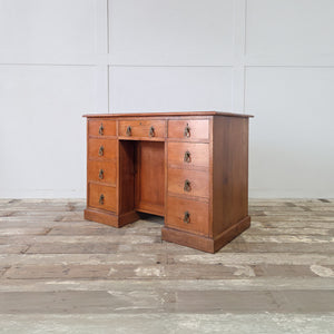 Late Victorian cherrywood desk with Aesthetic Movement brass handles and central kneehole cupboard

