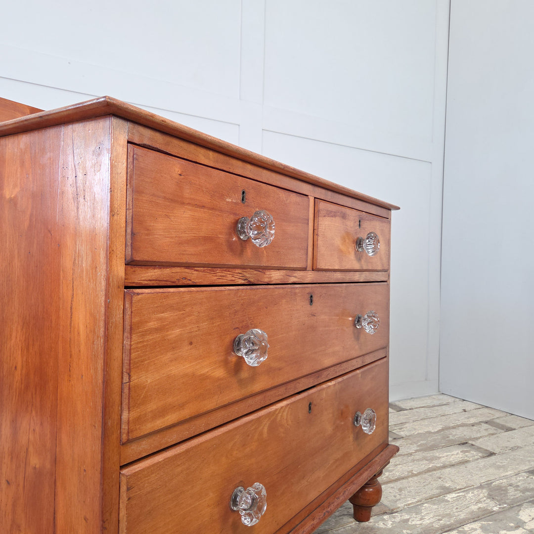 Antique 19th century Victorian chest of drawers in mahogany with two short drawers above two long graduated drawers, fitted with original glass knobs, shaped upstand and bun feet, a well-proportioned four drawer chest offering generous bedroom storage or use as a hallway storage piece.