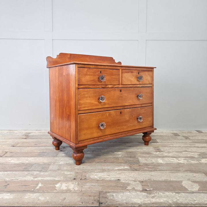 A smart Victorian mahogany chest of drawers with two short over two long drawers, each with original glass knobs, raised on bun feet with a shaped upstand to the top, a well-made 19th century four drawer chest providing storage for clothing and linens, perfect for bedroom or hallway interiors.
