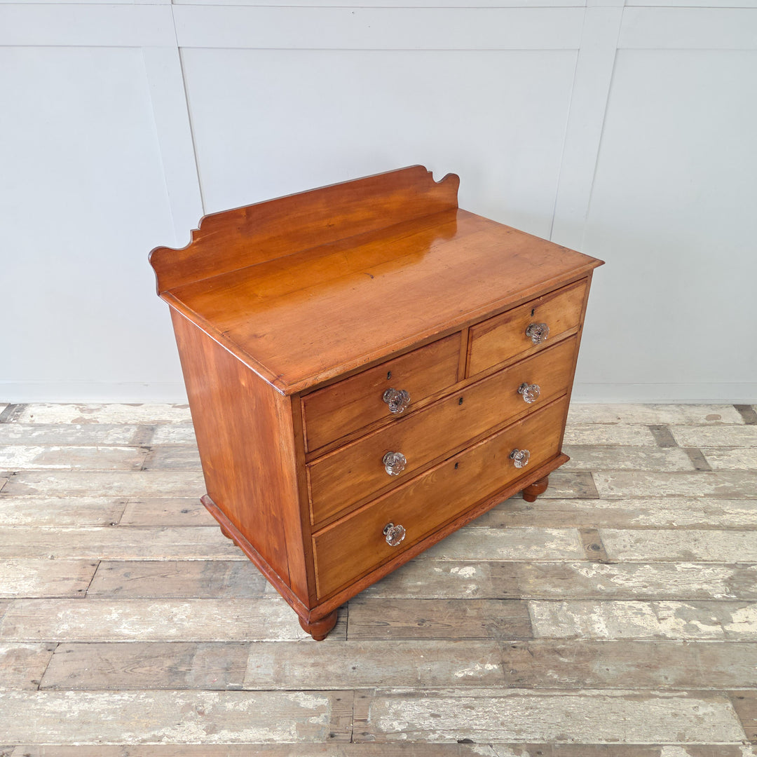 Victorian mahogany four drawer chest from the 19th century, comprising two short over two long graduated drawers, fitted with original glass knobs, with a shaped upstand and bun feet, a classic antique chest of drawers that is well-made, practical and suitable for bedroom or hallway storage.
