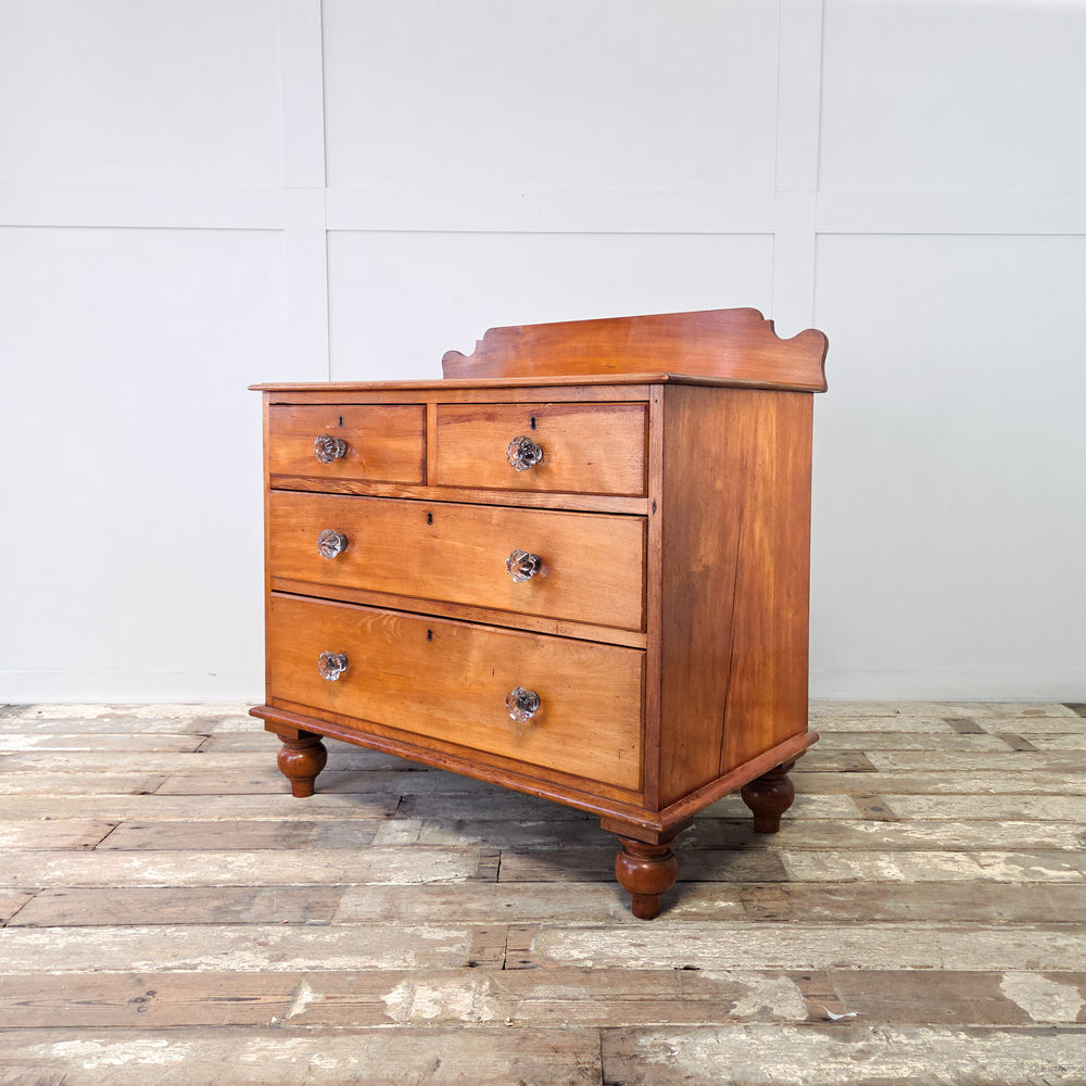 A Victorian chest of drawers in mahogany with two short over two long graduated drawers, original glass knobs, shaped upstand and bun feet, a 19th century four drawer chest of good proportions and practical design, perfect for bedroom storage or hallway use in an antique-inspired hom