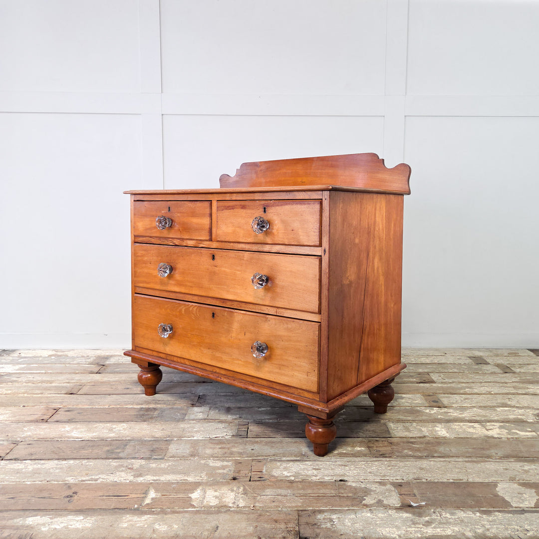 A Victorian chest of drawers in mahogany with two short over two long graduated drawers, original glass knobs, shaped upstand and bun feet, a 19th century four drawer chest of good proportions and practical design, perfect for bedroom storage or hallway use in an antique-inspired hom