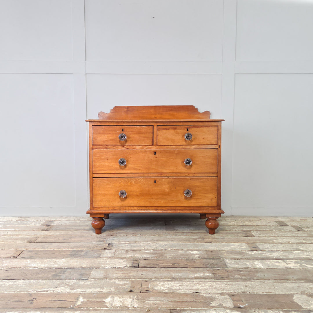 A Victorian mahogany chest of drawers, robust and well-made, with two short over two long graduated drawers, fitted with original glass knobs, shaped upstand and bun feet, a practical 19th century antique four drawer chest suited to use as bedroom drawers or hallway storage in the home.