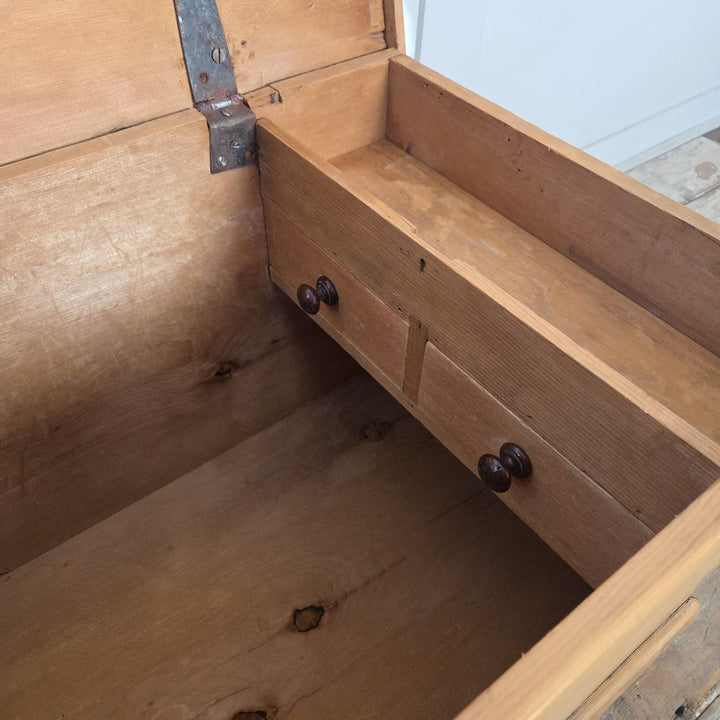 A Victorian pine storage chest with hinged lid and internal drawers, finished in clear wax to reveal the warm colour and texture of the pine. A rustic farmhouse blanket box or antique trunk providing generous enclosed storage.