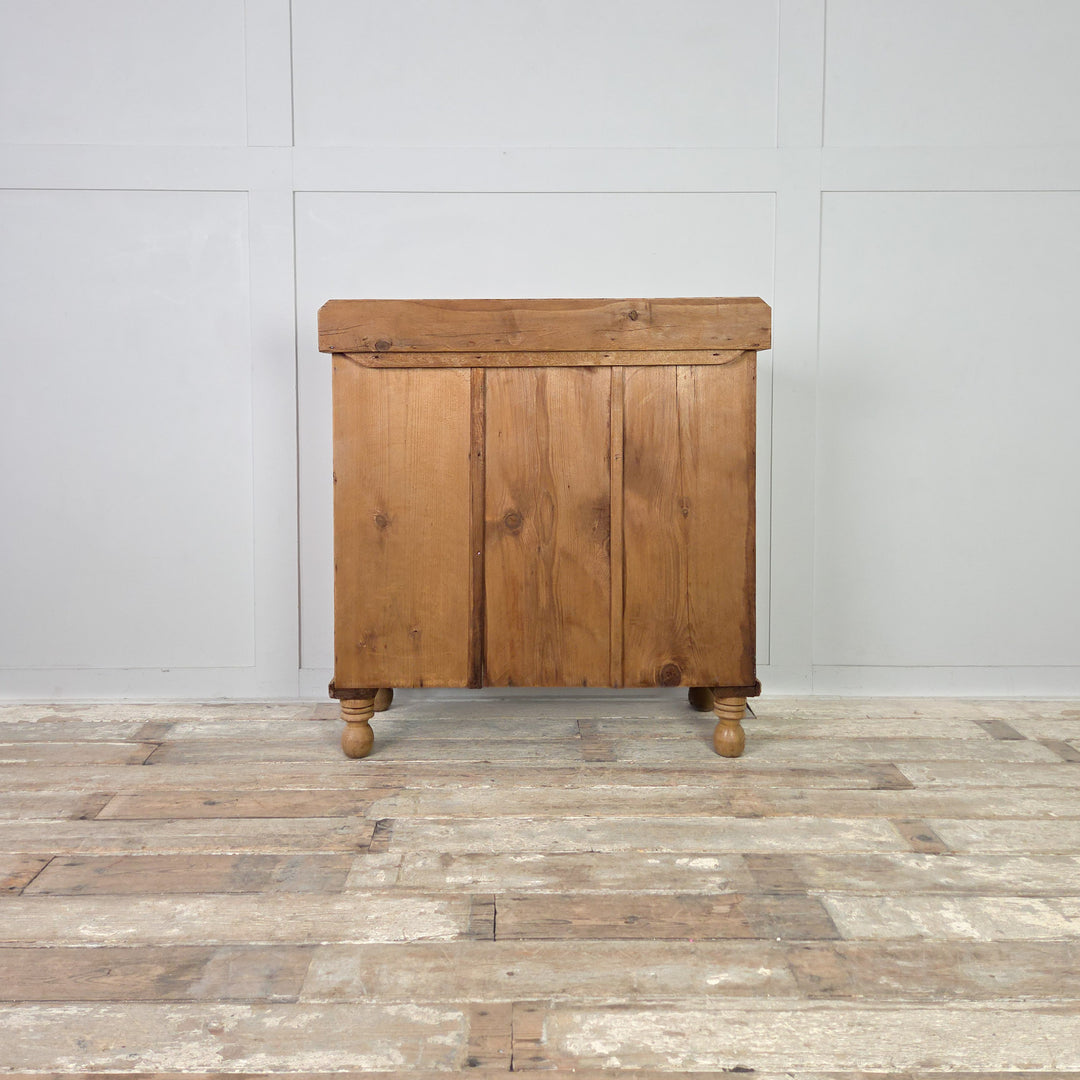 A late 19th-century Victorian pine chest of drawers with a two-over-two layout, original wooden knobs and traditional bun feet, sealed in clear wax to protect its warm patina. A beautiful antique storage piece that suits rustic, farmhouse and country-style interiors.