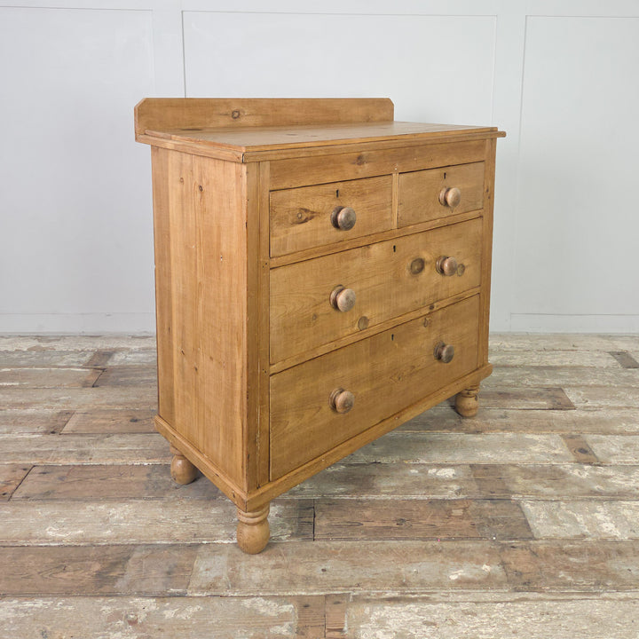 An antique Victorian pine dresser featuring four drawers, an upstand to the top and bun feet typical of the period. Finished in clear wax, this versatile piece can be styled as a bedroom chest, sideboard or country hallway storage within a farmhouse or cottage setting.