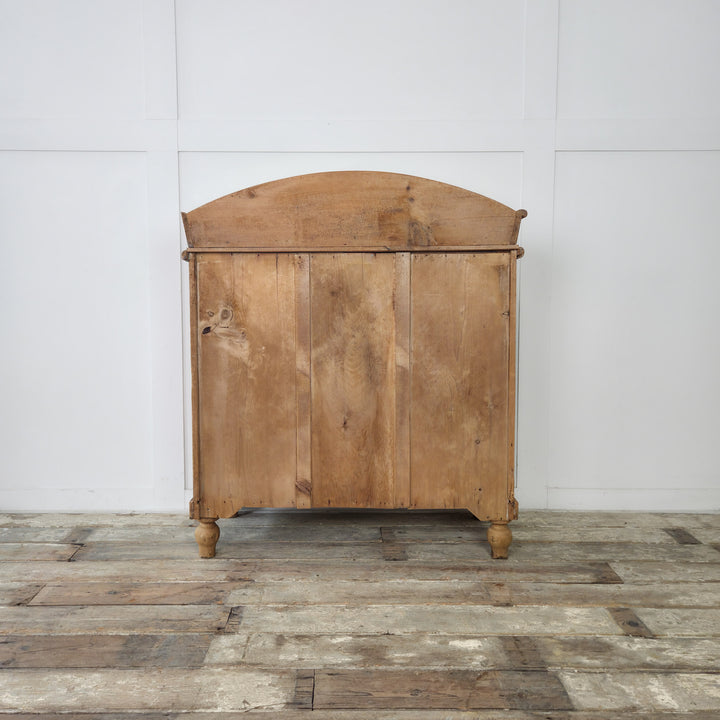 An antique pine bedroom furniture piece with four drawers, bun feet, and gallery back, designed to complement traditional interiors