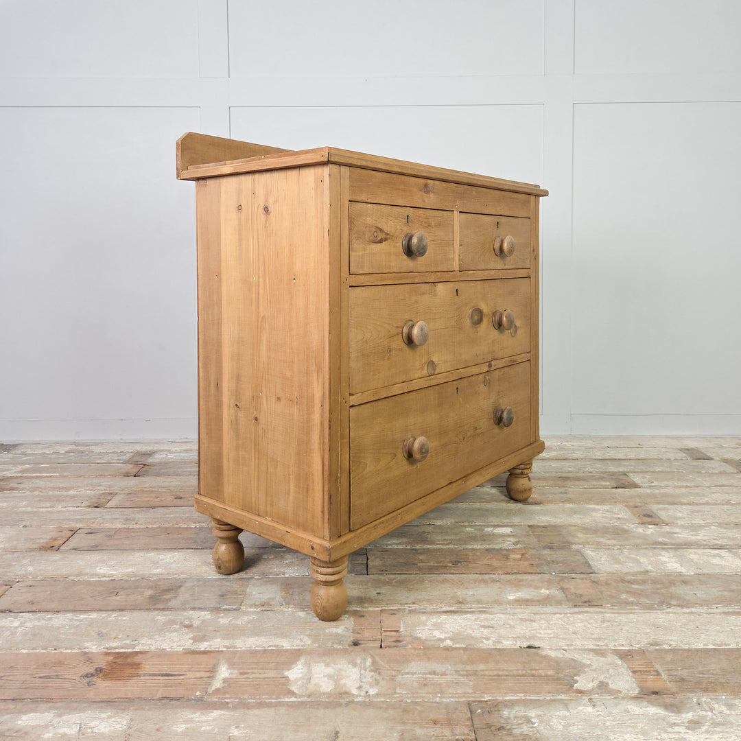 A late 19th-century Victorian pine chest of drawers with four drawers in a two-over-two layout, standing on traditional bun feet and sealed in clear wax to enhance its mellow patina, offering useful antique storage for the home.