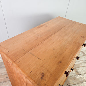 A Victorian antique pine chest of drawers with four drawers arranged in a graduated two over two layout. The chest features turned wooden knobs, a moulded edge to the top, and shaped bracket feet.
