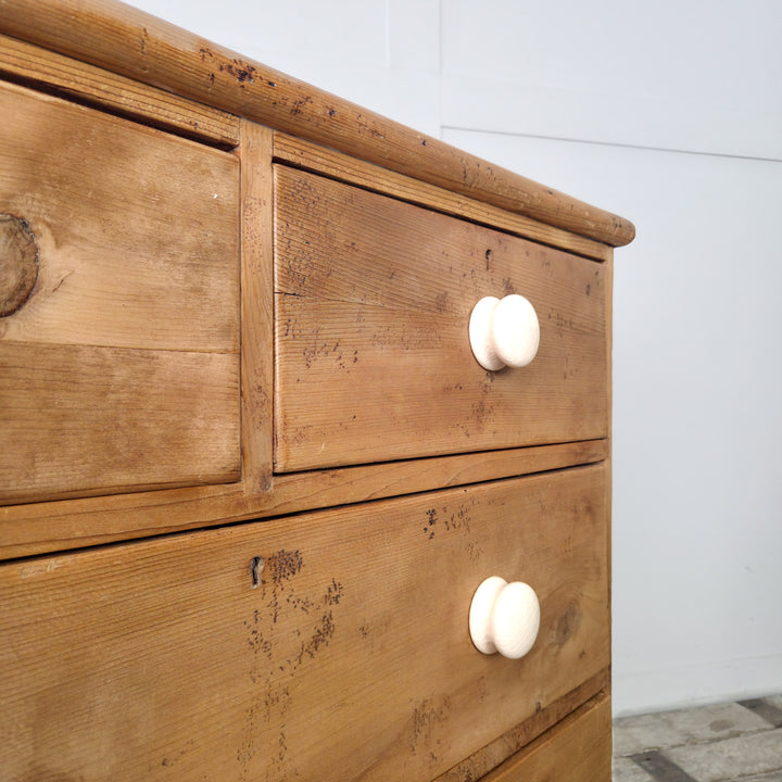 A 19th century chest of drawers in solid pine, featuring decorative gallery back and ceramic knobs, perfect for home organization