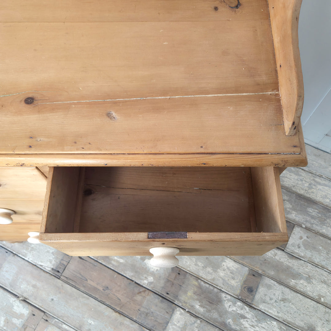 A Victorian pine storage chest with ceramic knobs and raised gallery back, combining vintage charm and practical design