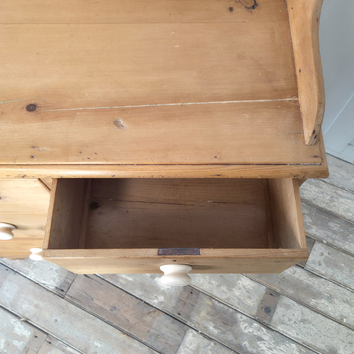 A Victorian pine storage chest with ceramic knobs and raised gallery back, combining vintage charm and practical design