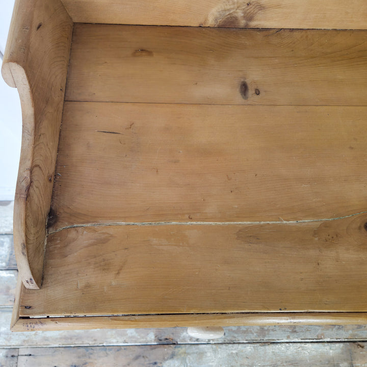 A 19th century English pine chest of drawers with decorative gallery back, bun feet, and functional storage drawers