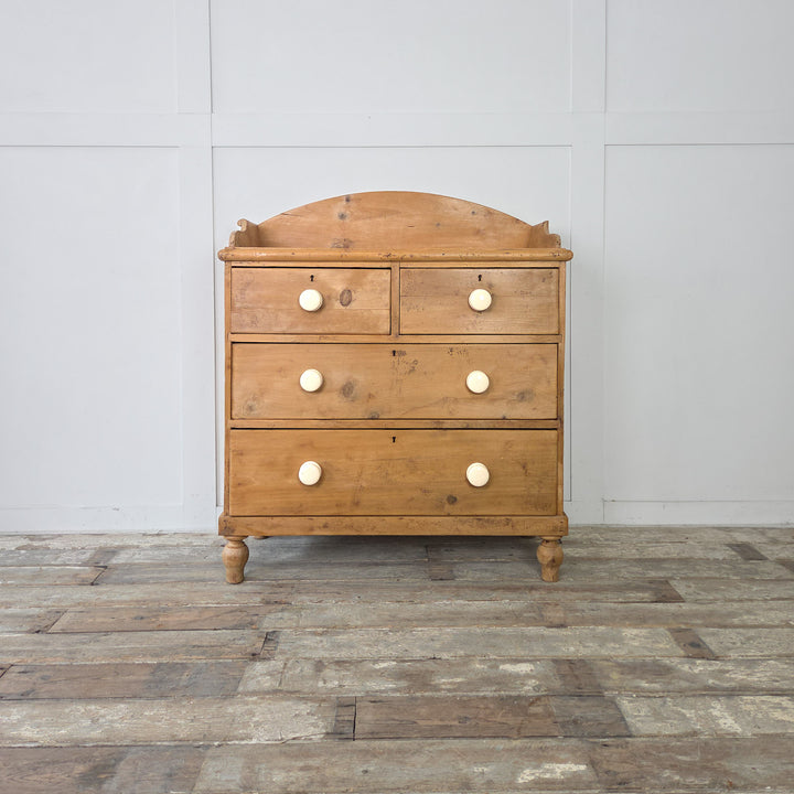 A four-drawer Victorian pine chest offering generous storage space and a classic profile with decorative knob details