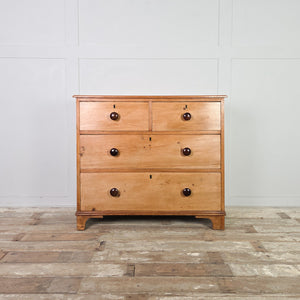 A 19th century Victorian antique pine chest of drawers with four graduating drawers arranged in a two short over two long layout. The chest includes turned wooden knobs, a moulded top edge, and decorative shaped bracket feet, giving the piece height.
