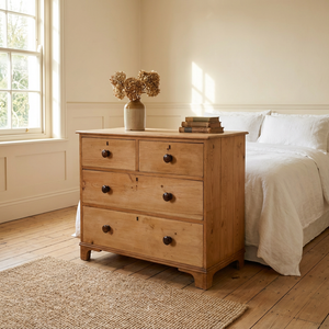 A Victorian antique pine chest of drawers from the 19th century featuring four drawers which graduate in depth, arranged in a two short over two long layout. Fitted with turned wooden knobs, the chest has a moulded top edge and stands on decorative shaped bracket feet, giving the piece height.
