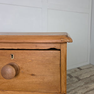 A Victorian pine chest of drawers dating from the 19th century with four drawers, bun feet and waxed finish. Later added knobs complete the look. This antique pine furniture piece provides useful storage while complementing farmhouse interiors, vintage-inspired bedrooms or rustic kitchens, blending seamlessly with traditional design schemes and country decor.