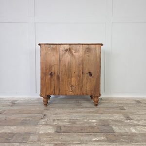 A Victorian pine chest of drawers from the 19th century, raised on decorative bun feet with four drawers and later added wooden knobs. The waxed pine finish enhances the natural grain, making this antique chest ideal for farmhouse interiors, country house bedrooms or rustic kitchens. A practical and stylish antique pine furniture storage solution.
