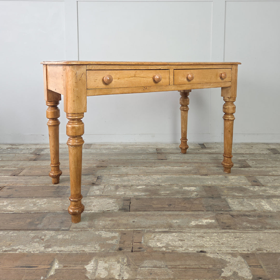A well-proportioned late Victorian pine console table, featuring two storage drawers and turned supports, finished in a honey-coloured wax that highlights the age and warmth of the wood.

