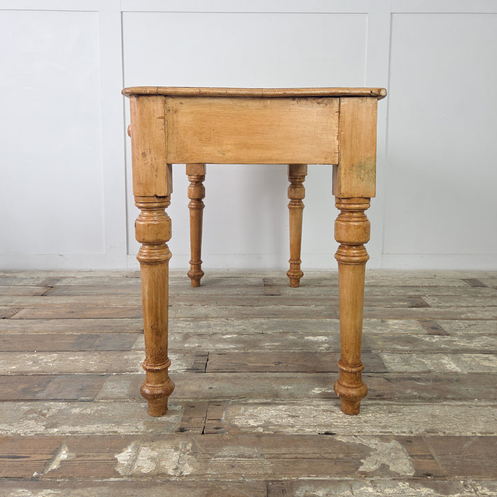 The Victorian console table in solid pine with turned wooden legs and a plain apron, featuring two drawers with wooden knobs and a wax-sealed surface that enhances its farmhouse appeal.

