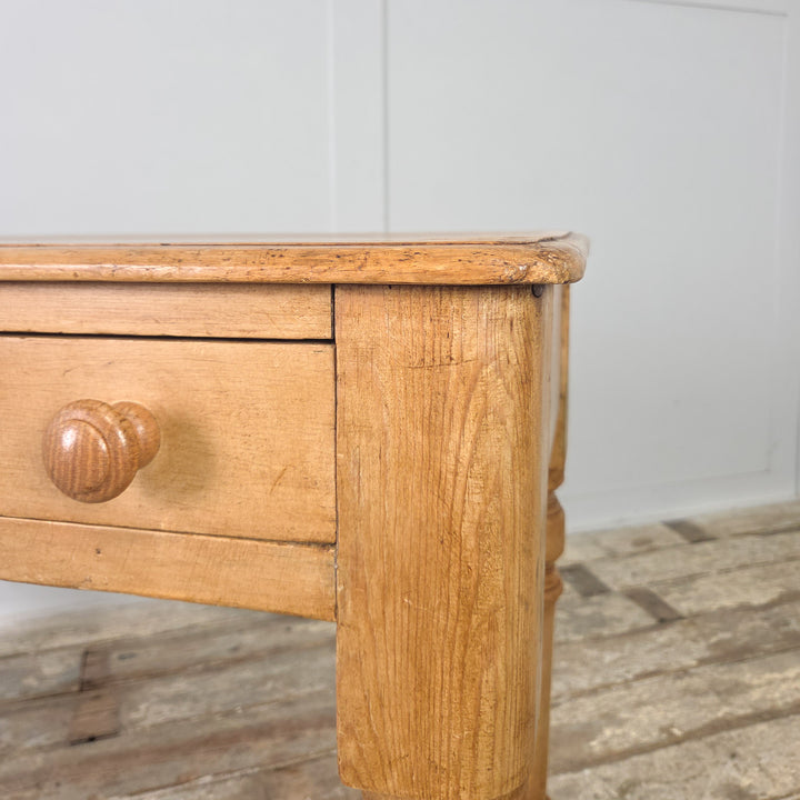 A late Victorian pine console table or writing desk with a simple, practical design, complete with two drawers and a natural waxed finish that brings out the warmth of the original pine.

