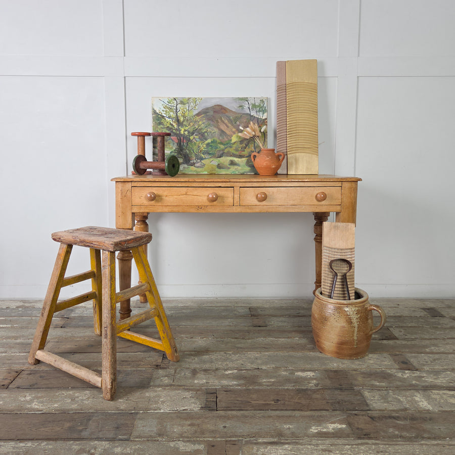 A 19th century Victorian pine console table with two drawers and turned legs, finished in a warm honey-toned patina. The drawers feature rustic wooden knobs and are set into a plain apron.
