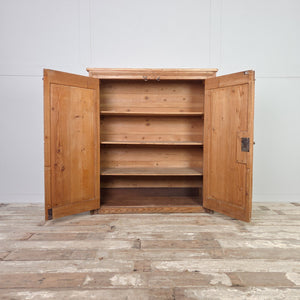 Rustic farmhouse pine cupboard dating to the Victorian period, with two front doors, brass fittings, and four internal fixed shelves for practical storage.
