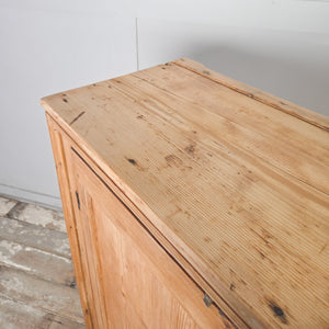 Victorian rustic farmhouse cupboard in pine, with twin panelled doors, brass cupboard hardware, and a shelved interior offering straightforward storage.
