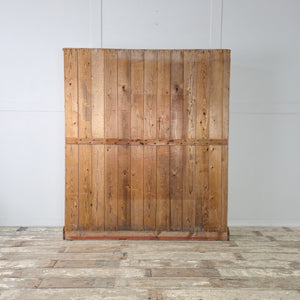 A large antique pine glazed cupboard with solid pine construction, full-length glazed double doors, and a waxed finish. The interior includes four adjustable shelves for flexible household storage.