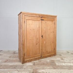 Rustic farmhouse cupboard in Victorian pine, featuring panelled double doors, brass cupboard fittings, and four internal shelves for storage.
