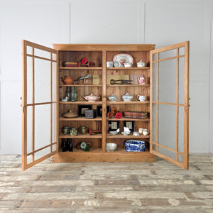 A functional antique glazed bookcase crafted from solid pine with a waxed finish. Fitted with frosted glass doors and adjustable shelving, offering a flexible solution for enclosed storage and display.

