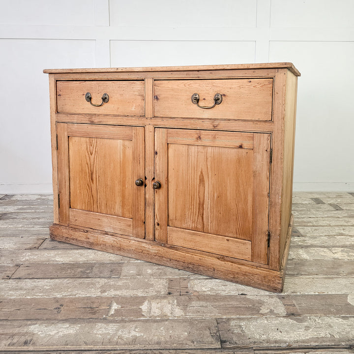 Two-door pine cupboard with spacious storage shelves.