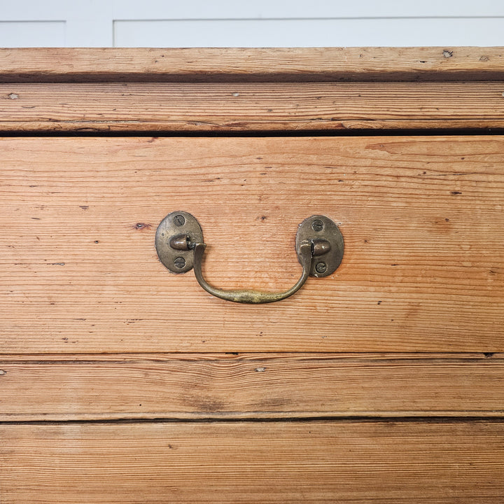 Durable pine cupboard with natural wood finish and brass accents.