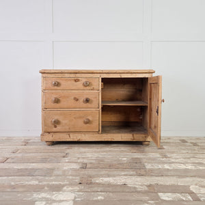 Country style pine cupboard with graduated drawers and original-style turned wooden knobs on the front.
