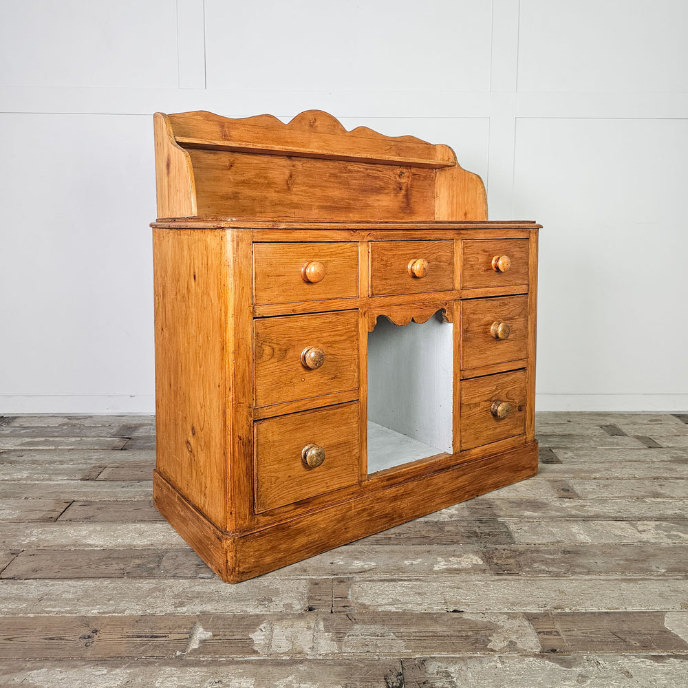 19th-century pine dresser with central cubby-hole and shelf for display.
