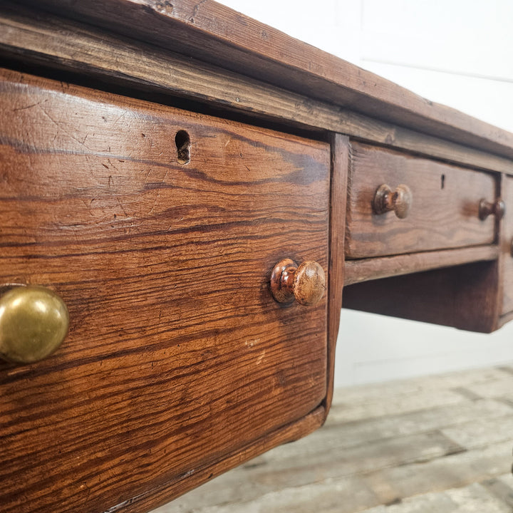 Antique pine table with generous top and three front drawers, supported on traditional turned legs