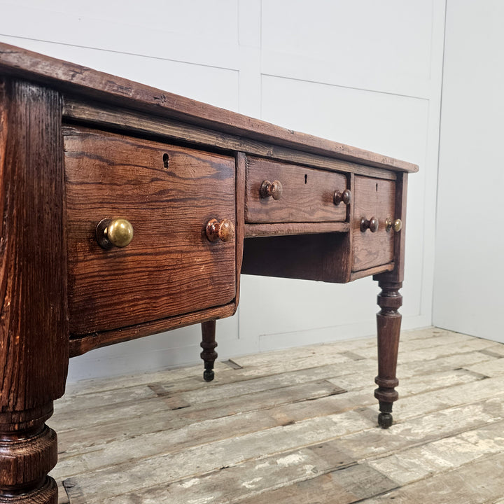 Farmhouse table made from antique pine with two-plank top, kneehole centre and hidden brass castors
