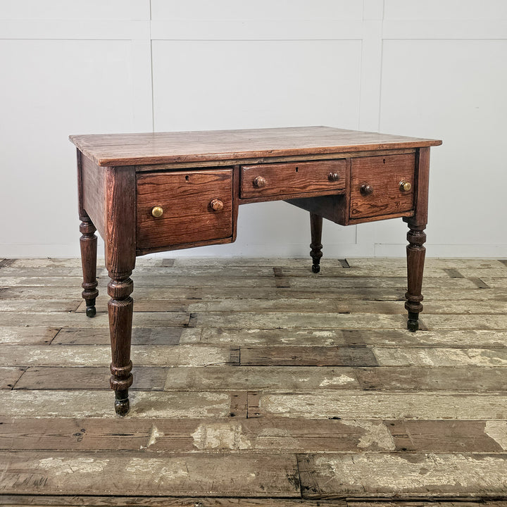 Early 20th century antique pine table with wide surface, turned legs and drawer arrangement around kneehole
