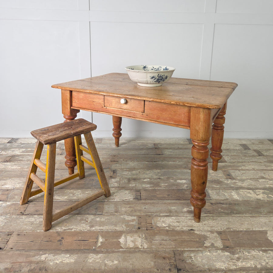 Antique Victorian pine farmhouse table with turned legs and single drawer, shown with warm aged pine patina and a scrubbed plank top, ideal for use in a rustic kitchen or country-style dining space.
