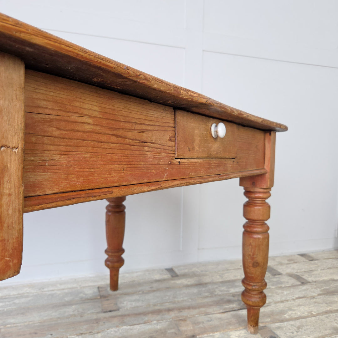 Early farmhouse table in antique stripped pine, ideal as a rustic kitchen table or desk in a home study, with visible knots, patina and traditional Victorian joinery.
