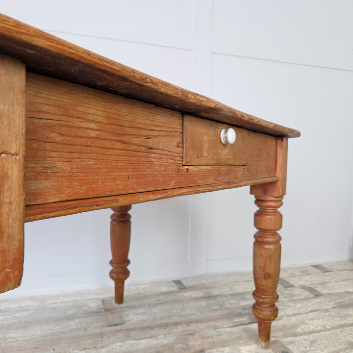 Early farmhouse table in antique stripped pine, ideal as a rustic kitchen table or desk in a home study, with visible knots, patina and traditional Victorian joinery.
