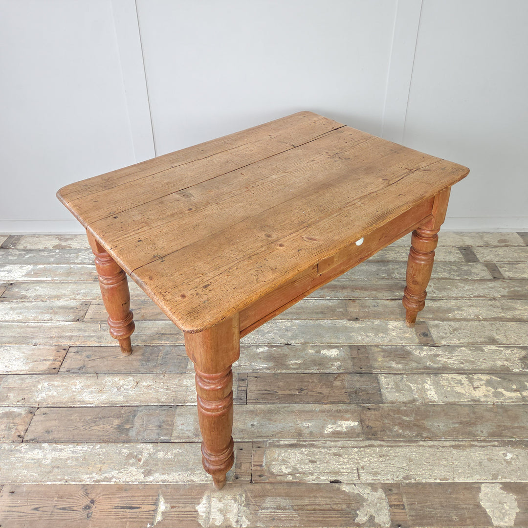 19th century pine table with a single drawer and ceramic knob, offering traditional farmhouse style and warm aged finish, ideal for small dining areas or multifunctional use.

