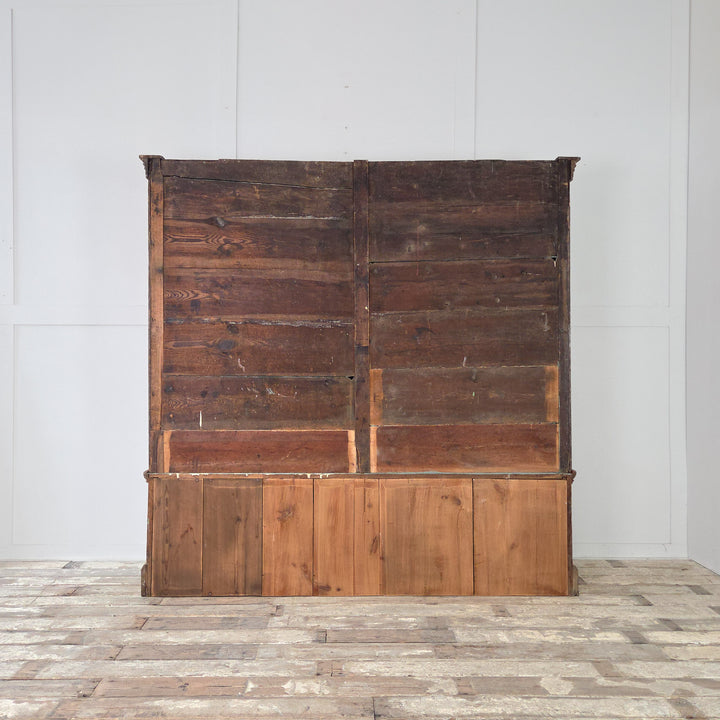 The Victorian 19th century housekeeper’s cupboard is crafted in solid English pine with upper panelled cupboards, fixed blue-painted shelving, two large drawers with brass handles, and a plinth base with cornice.