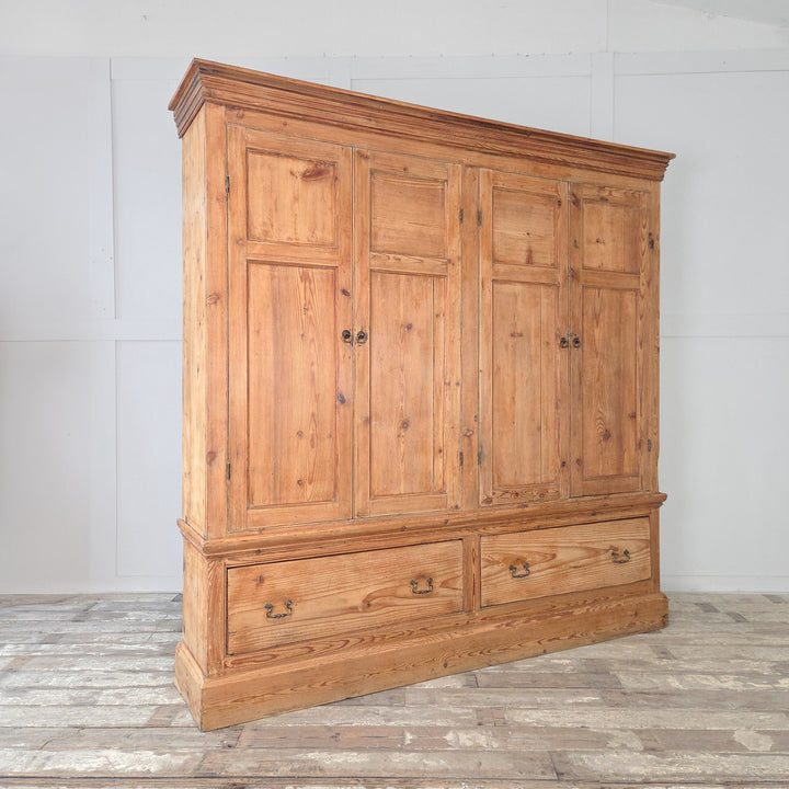 The 19th century Victorian housekeeper’s cupboard is made from solid English pine and features two tall panelled cupboard doors, fixed shelving with a painted blue interior, and two large base drawers with brass handles.