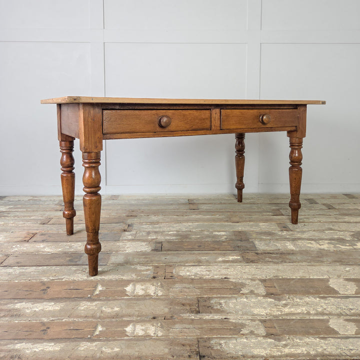 Antique pine kitchen table with ample workspace, Victorian turned legs, two drawers for storage, and rustic farmhouse charm, perfect for traditional or modern interiors.
