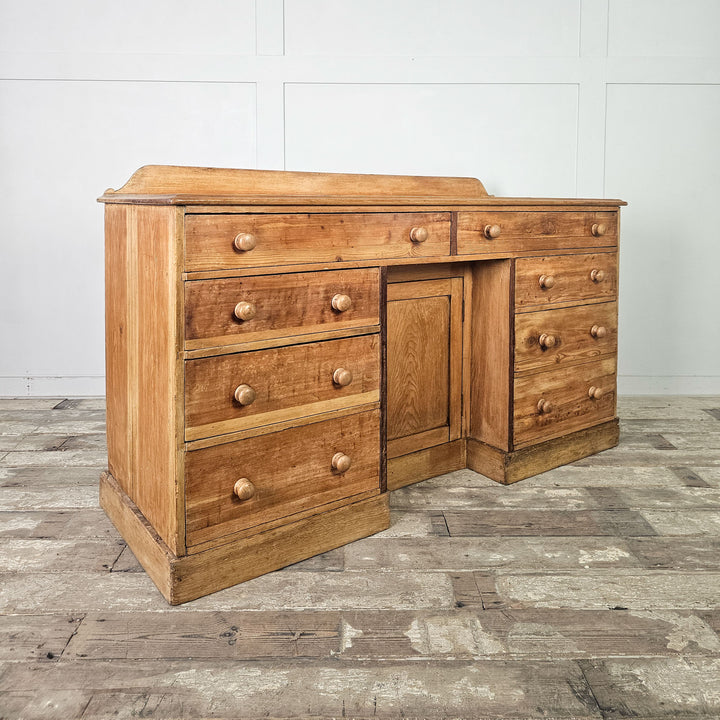 Pine sideboard with a natural wood finish and eight drawers.
